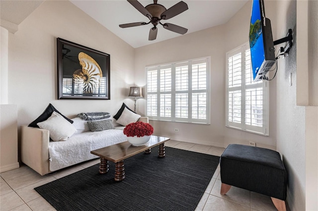 living area featuring lofted ceiling, light tile patterned floors, and ceiling fan