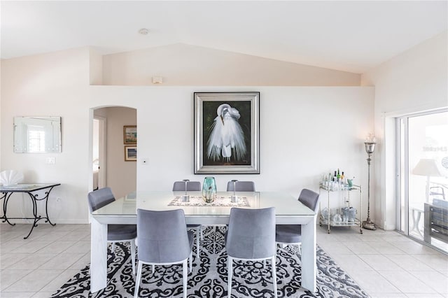 dining room featuring lofted ceiling and light tile patterned floors