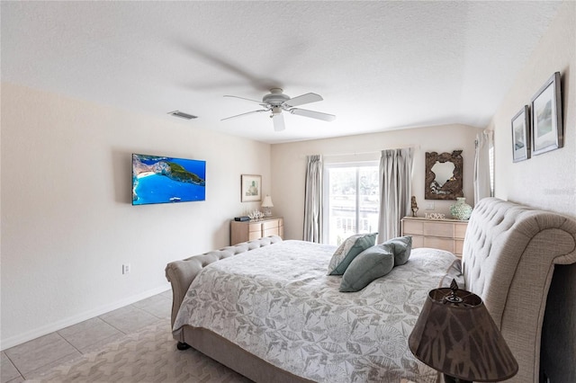 bedroom with light tile patterned flooring, ceiling fan, and a textured ceiling