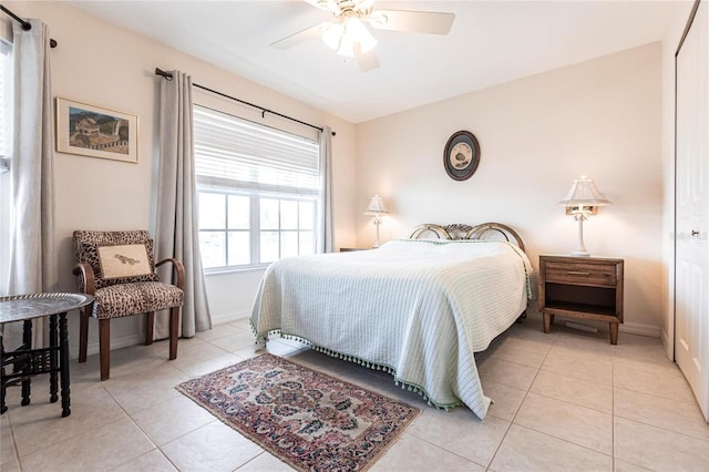 tiled bedroom with ceiling fan and a closet