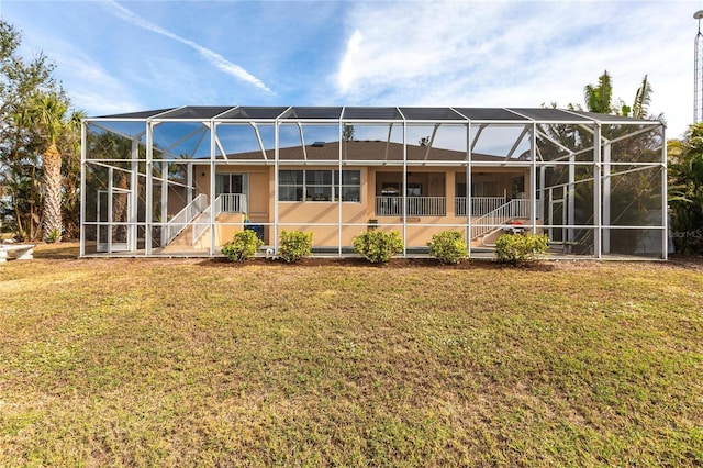 rear view of house with a lanai and a yard