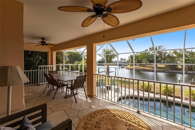 sunroom featuring a water view and ceiling fan