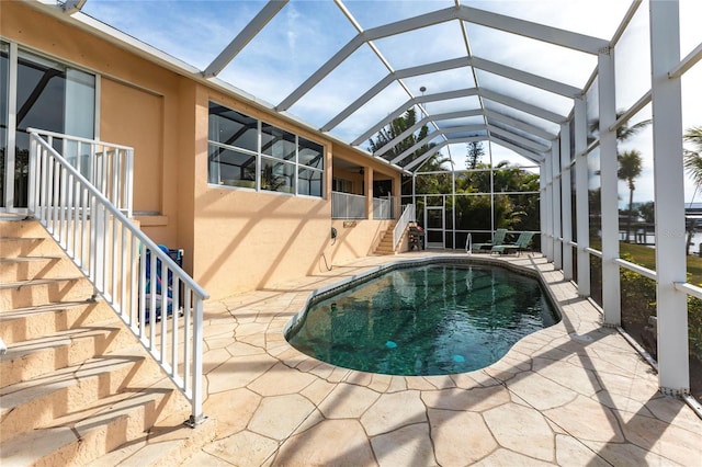 view of swimming pool featuring a patio and glass enclosure