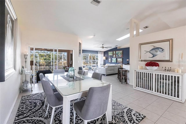 dining room featuring lofted ceiling, light tile patterned floors, and ceiling fan