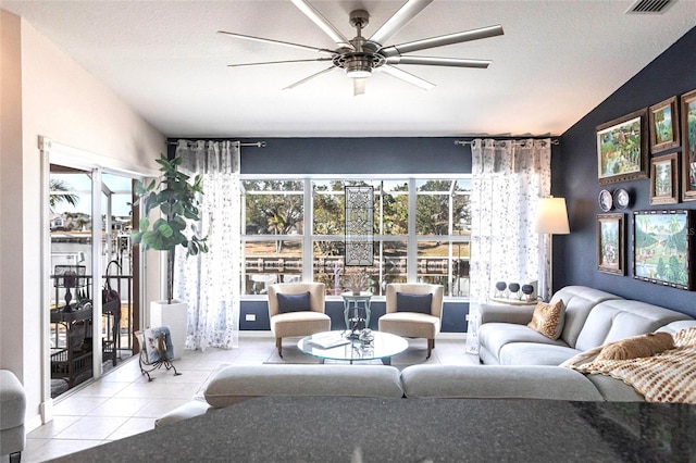 tiled living room with ceiling fan, lofted ceiling, and a textured ceiling