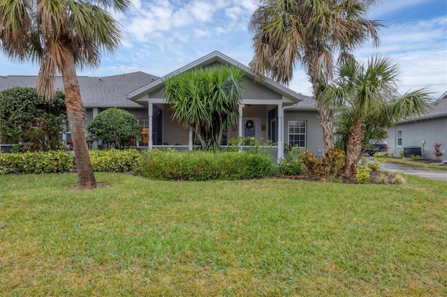 view of front of house with central AC and a front yard