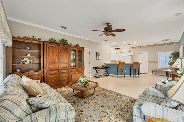 living room with light tile patterned flooring, ornamental molding, and ceiling fan