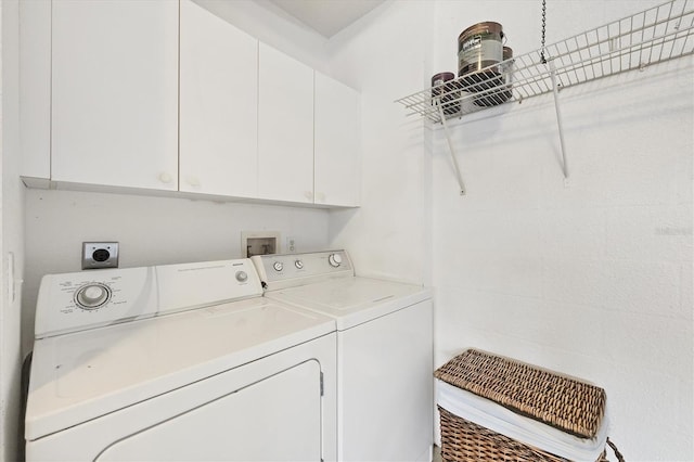 washroom featuring separate washer and dryer and cabinets