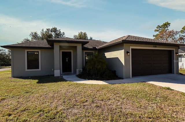 prairie-style home with a garage and a front lawn