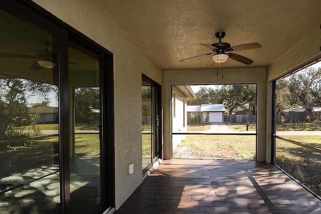 unfurnished sunroom with ceiling fan