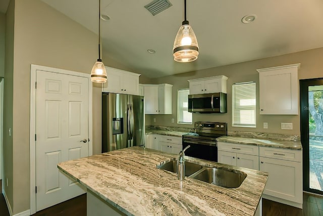 kitchen featuring white cabinetry, stainless steel appliances, and decorative light fixtures