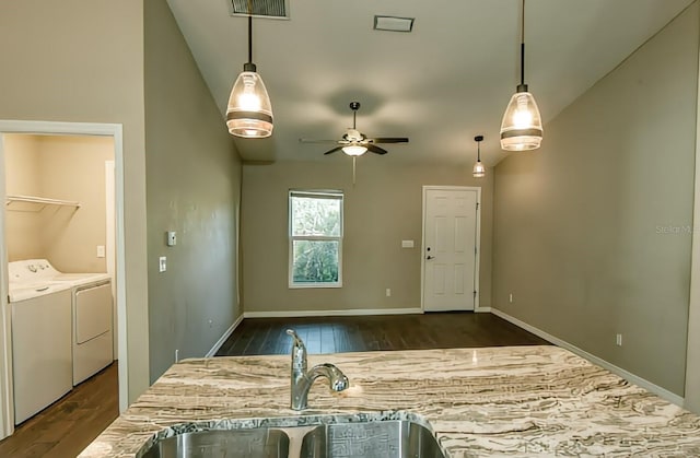 kitchen with lofted ceiling, pendant lighting, and independent washer and dryer