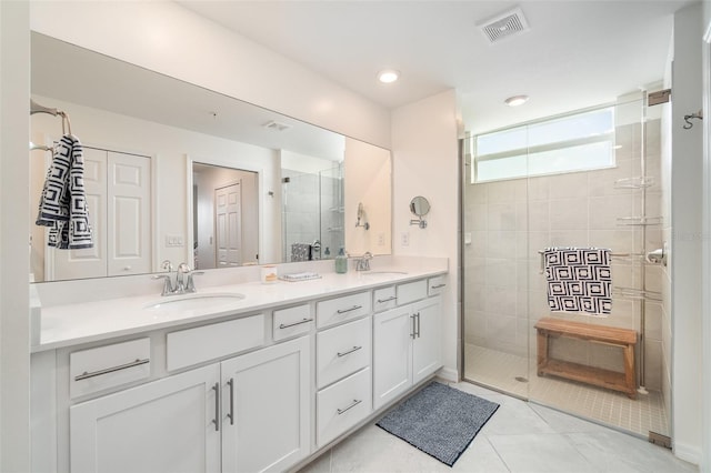 bathroom with walk in shower, vanity, and tile patterned flooring