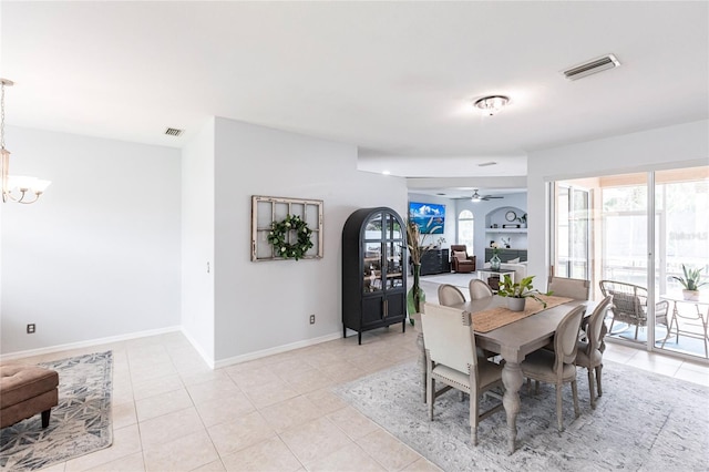 tiled dining room featuring ceiling fan with notable chandelier