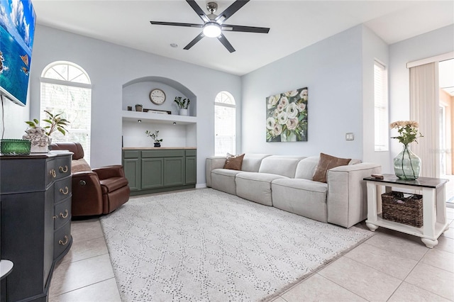 living room featuring built in shelves, light tile patterned flooring, and a wealth of natural light