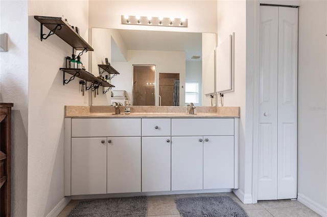 bathroom with a shower with door, tile patterned floors, and vanity