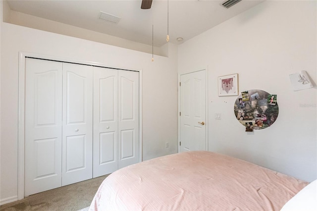 bedroom with a closet, ceiling fan, and light carpet