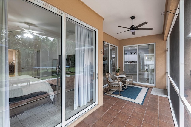 unfurnished sunroom featuring ceiling fan