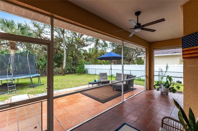 unfurnished sunroom featuring ceiling fan