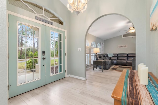 doorway featuring a chandelier, french doors, light hardwood / wood-style flooring, and lofted ceiling