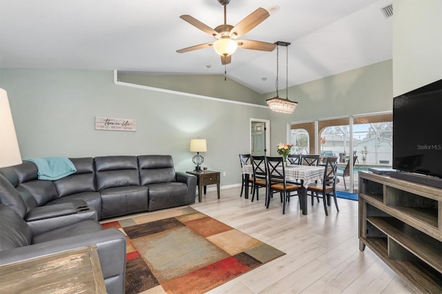 living room with light hardwood / wood-style floors, vaulted ceiling, and ceiling fan