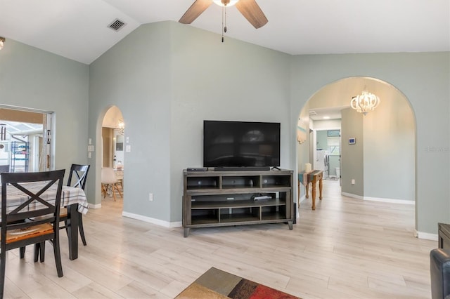 living room with light hardwood / wood-style floors, ceiling fan with notable chandelier, and vaulted ceiling