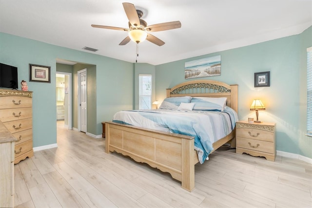 bedroom with ceiling fan, light hardwood / wood-style floors, and ensuite bath