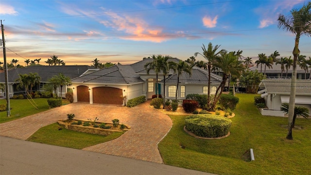 view of front facade with a yard and a garage