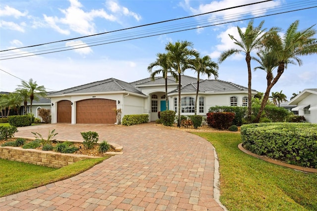 single story home with a garage and a front lawn