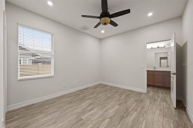 unfurnished bedroom with ensuite bath, light hardwood / wood-style flooring, and ceiling fan