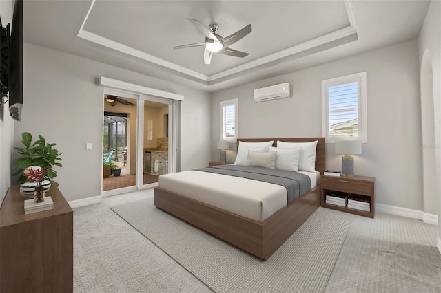 carpeted bedroom with a tray ceiling, access to outside, and an AC wall unit