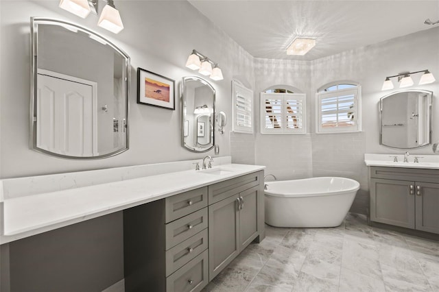 bathroom with vanity, a bathtub, and tile walls