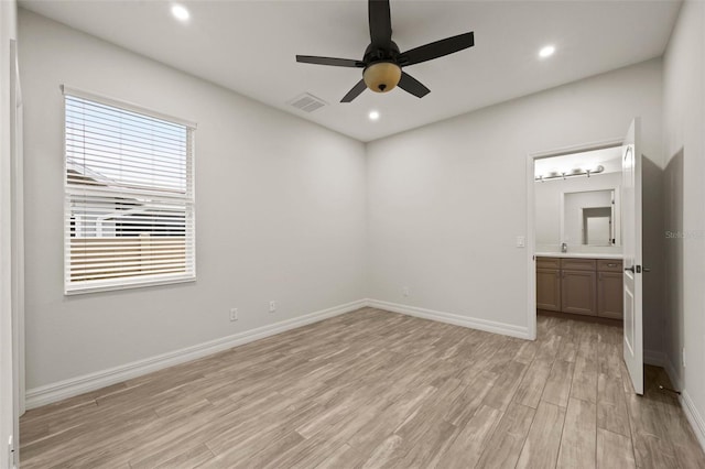 unfurnished bedroom with ensuite bath, ceiling fan, and light wood-type flooring