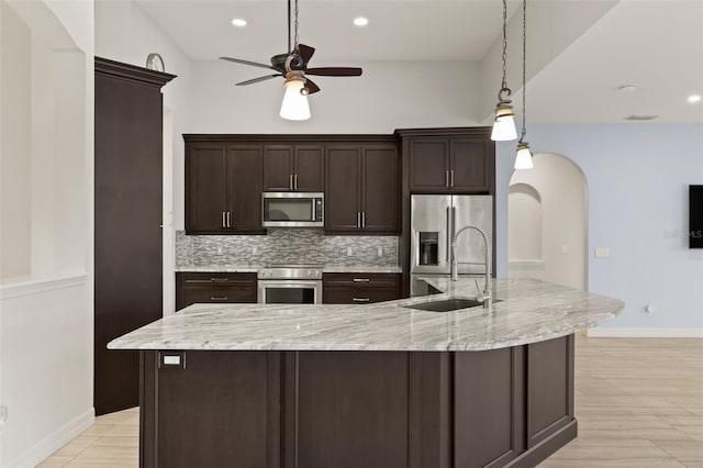 kitchen with sink, decorative light fixtures, appliances with stainless steel finishes, a large island, and backsplash