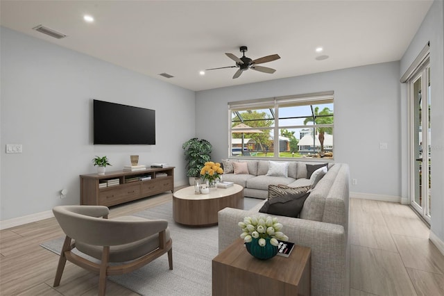 living room featuring ceiling fan and light hardwood / wood-style flooring