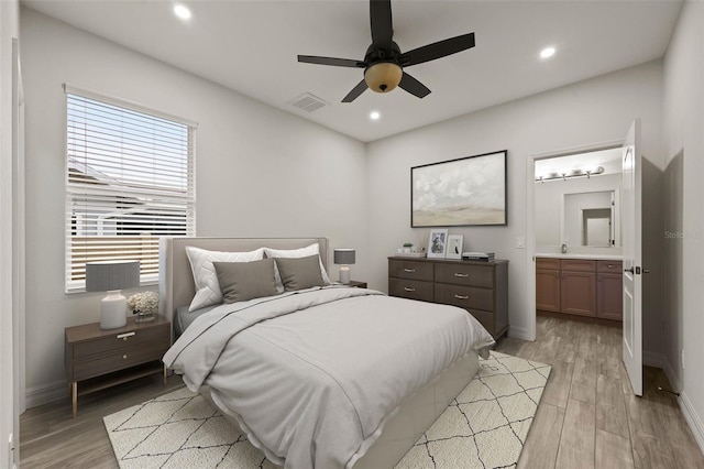 bedroom with light hardwood / wood-style flooring, ceiling fan, and ensuite bathroom