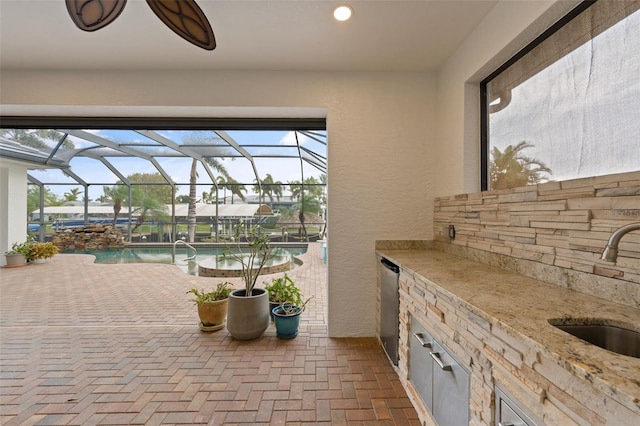 view of patio featuring a lanai and sink