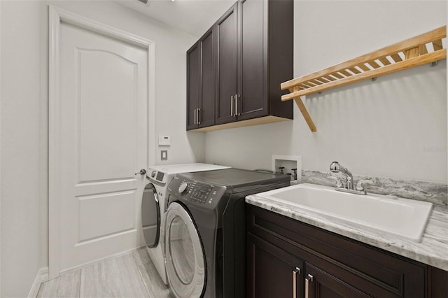 laundry area featuring cabinets, washer and dryer, and sink