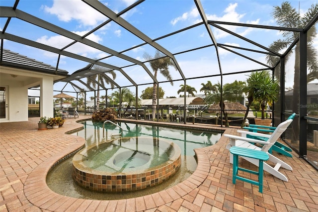 view of pool featuring a patio area, glass enclosure, and a jacuzzi