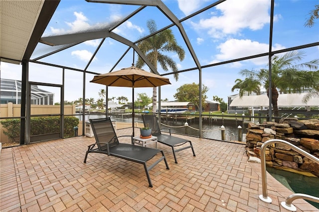 view of patio / terrace featuring a lanai and a water view