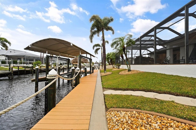 dock area with a water view, a yard, and glass enclosure