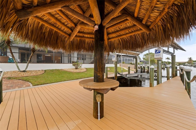 view of dock featuring a water view and a yard