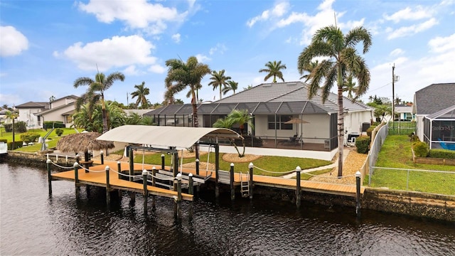 view of dock with a yard, a lanai, and a water view