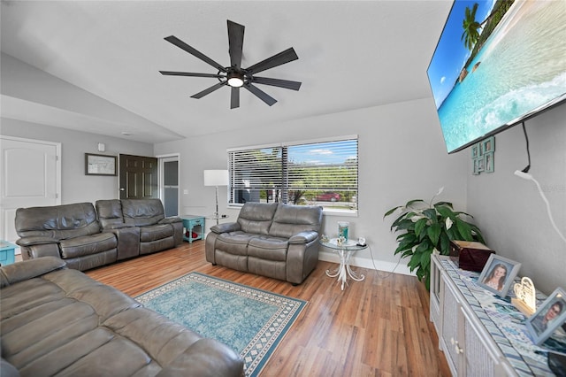 living room with light hardwood / wood-style flooring, vaulted ceiling, and ceiling fan