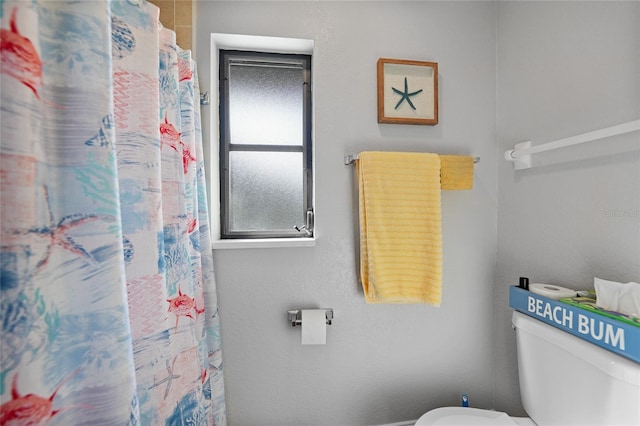 bathroom with curtained shower and toilet