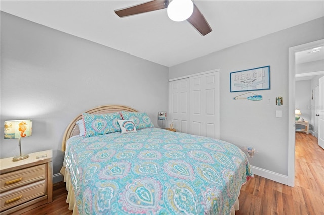 bedroom with wood-type flooring, ceiling fan, and a closet