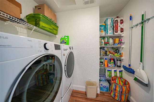 washroom with hardwood / wood-style floors and washer and clothes dryer