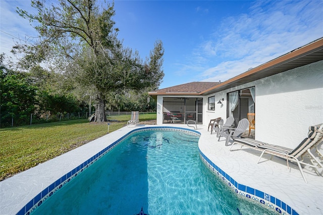 view of swimming pool featuring a patio area, a sunroom, and a lawn