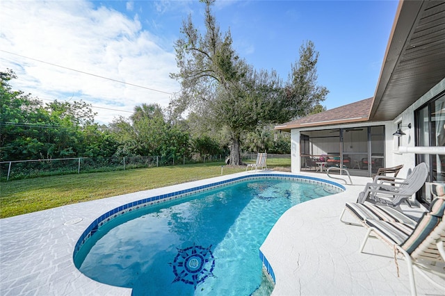 view of pool with a patio, a sunroom, and a lawn