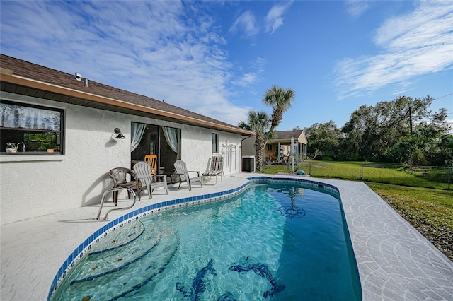 view of swimming pool with central AC, a patio, and a lawn